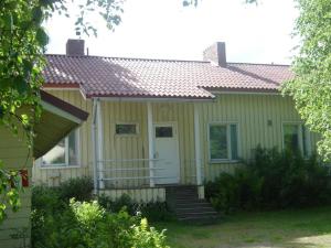 una pequeña casa amarilla con una puerta blanca y escaleras en Huoneistohotelli Jokikeskus, en Kemi