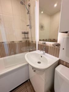 a white bathroom with a sink and a bath tub at Kerese tn Apartment 1-2 persons in Narva