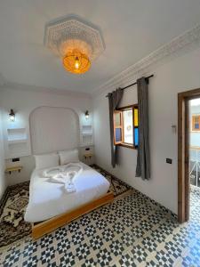 a bedroom with a bed and a chandelier at Riad Le Sultan Rouge And Spa in Marrakesh +26 photos