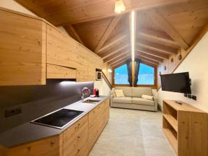 a kitchen with a stove and a couch in a room at Rosengarden Alpine Residence in Valdidentro