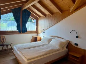 a bedroom with a bed in a room with a window at Rosengarden Alpine Residence in Valdidentro
