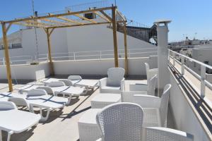 a balcony with white chairs and tables on a ship at Terrazza sul Borgo in Polignano a Mare +3 photos