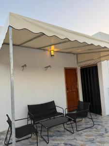a patio with chairs and an umbrella at Palm & Tide Kenitra Residence in Kenitra