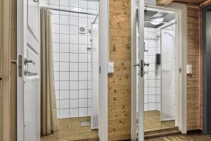 a bathroom with white tiled walls at Astra Whale - Waterfront Boutique Hostel in Lofoten in Kabelvåg