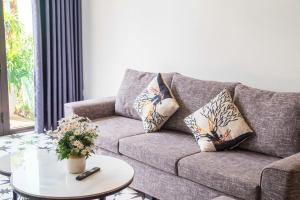a living room with a couch and a table with pillows at Sweet Apartment Sa Pa in Sapa +23 photos
