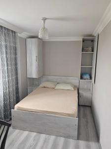 a small bedroom with a bed with a shelf at House Dea Dea in Chakvi