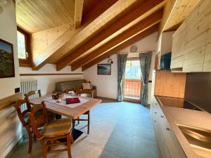 a kitchen and dining room with a wooden table at Rosengarden Alpine Residence in Valdidentro