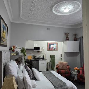a bedroom with a bed and a kitchen in it at The Wentworth Guest House in Krugersdorp