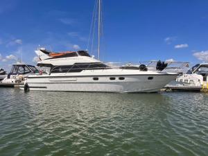 a white boat is docked in the water at The North Bank in Poole