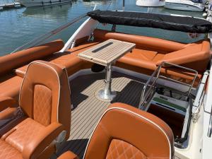 a boat with orange seats and a table on the deck at The North Bank in Poole