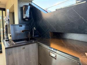 a kitchen with a black counter top with a sink at The North Bank in Poole