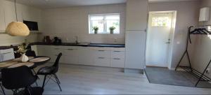 a kitchen with white cabinets and a table and a window at Apartment Sollid - Your comfortable accommodation in Huskvarna +2 photos