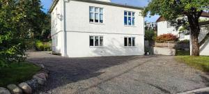 a white house with a driveway in front of it at Apartment Sollid - Your comfortable accommodation in Huskvarna