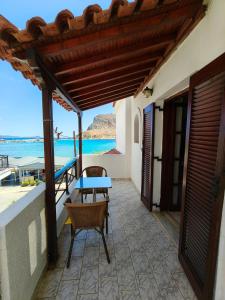 eine Terrasse mit Tisch und Stühlen und dem Meer in der Unterkunft AGNANTIO in Monemvasia