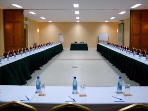 una gran sala de conferencias con botellas de agua en las mesas en South Beach Resort en Dar es Salaam