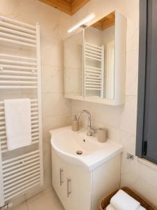 a white bathroom with a sink and a mirror at Aeolian Garden in Mytilene +5 photos