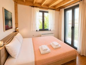 a bedroom with a bed with two towels on it at Aeolian Garden in Mytilene