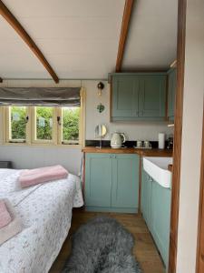 a small kitchen with a bed in a room at Arcadia Shepherds Hut in Ashwater