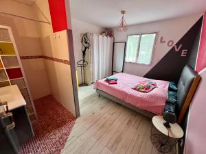 a small bedroom with a pink bed in a room at Chez Christelle in Audenge