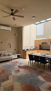 a living room with a ceiling fan and a table and chairs at Thuraya chalet in Nizwa