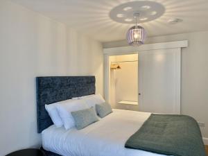 a bedroom with a white bed and a purple lamp at Apartment 299 - Clifden in Clifden