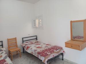 a bedroom with a bed and a mirror and a chair at HASH # SAAd in Marsa Matruh