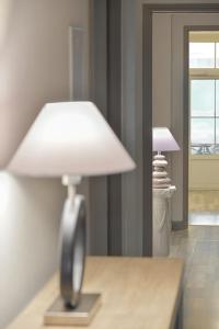 a white lamp sitting on a table in a room at Hôtel Les Comtes de Pardiac in Marciac