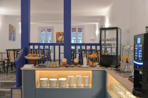 a restaurant with a counter with plates on it at Hôtel Les Comtes de Pardiac in Marciac