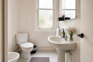 a white bathroom with a toilet and a sink at Urban Hub in A Coruña