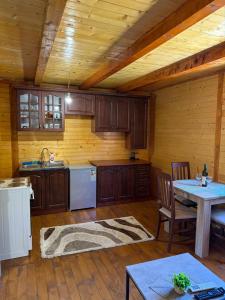 a kitchen with wooden cabinets and a table at Laki House Skadar lake in Železnička Stanica Zeta