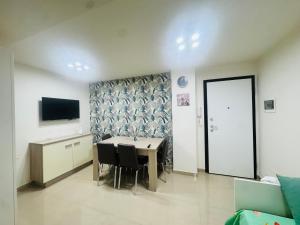 ein Esszimmer mit Tisch, Stühlen und Fernseher in der Unterkunft FaraHome in Acitrezza