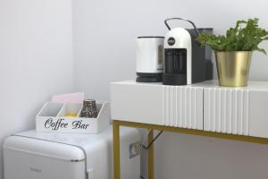 a coffee set on a white counter next to a refrigerator at Domus Mirea in Aquiléia