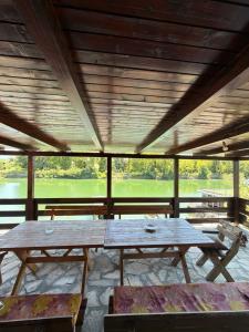 two picnic tables in a pavilion with a view at Laki House Skadar lake in Železnička Stanica Zeta
