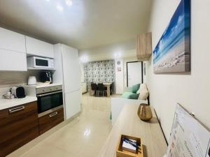 eine Küche und ein Wohnzimmer mit Sofa und Tisch in der Unterkunft FaraHome in Acitrezza