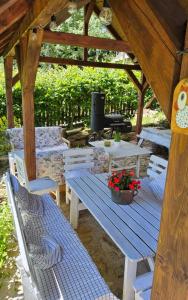 a picnic table and chairs under a wooden gazebo at Chalupa pod Lysou - Apartma 4rooms in Rokytnice nad Jizerou