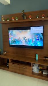 a flat screen tv sitting on a wooden entertainment center at Sofra service apartment by LUXE with swinging pool in Mysore