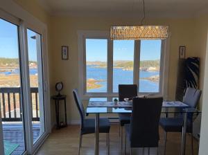 a dining room with a table with a laptop on it at The Wild Rose Cottage & Bird's Nest in Twillingate