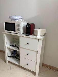 a white cabinet with a microwave on top of it at Casa Mediterraneo in Catania