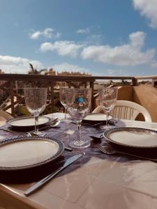 a table with plates and glasses on top of a table at Tropisal Apartamento in Santa Maria