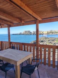 a wooden deck with a table and chairs and the ocean at Camping Jonio in Catania