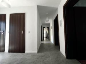 a hallway with white walls and wooden doors at Yanevi Apartments in Chernomorets