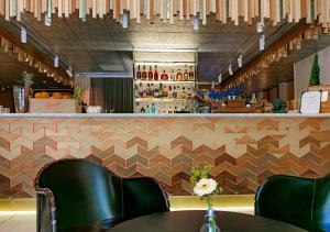 a restaurant with a counter with chairs and a bar at Hotel Klaus K in Helsinki