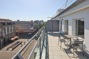 a balcony with chairs and a table on a building at Cinema City Hotel Europaplatz Karlsruhe - Brand New Boutique Hotel 2025 - in Karlsruhe