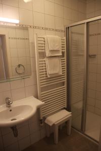 a white bathroom with a sink and a shower at Landhaus Strussnighof in Pörtschach am Wörthersee +34 photos