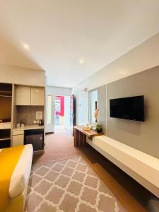 a room with a bed and a flat screen tv at Villa Abadi Resort VAR in Pantai Kok