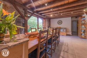 a dining room with a long table and chairs at Les Gîtes Chapô Julô in Giez