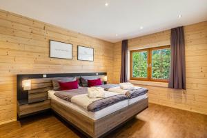 a bedroom with a large bed in a wooden wall at Ferienhaus Traum Teufel in Hettingen +37 photos