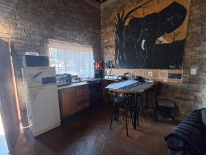 a kitchen with a refrigerator and a table in it at Bushveld Bliss in Marloth Park