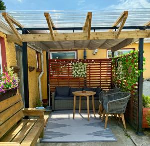 a patio with a table and chairs under a pergola at Padoro Lodge in Kildare
