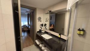 a bathroom with a sink and a mirror at Adana Time Business Hotel in Adana